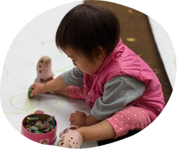 クレヨンで絵を描いている子